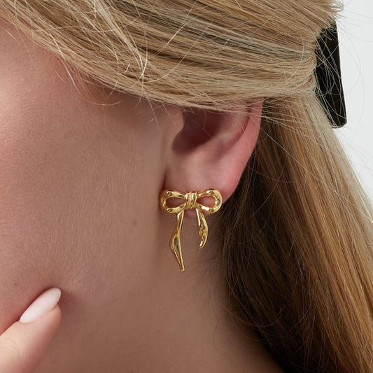 Gouden oorbel met een subtiele strikvorm