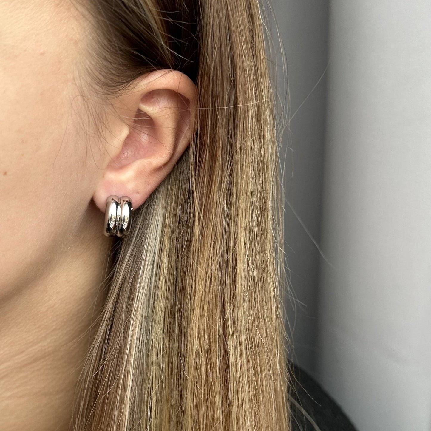 Moderne en minimalistische zilveren oorring met een speels dubbellaags design