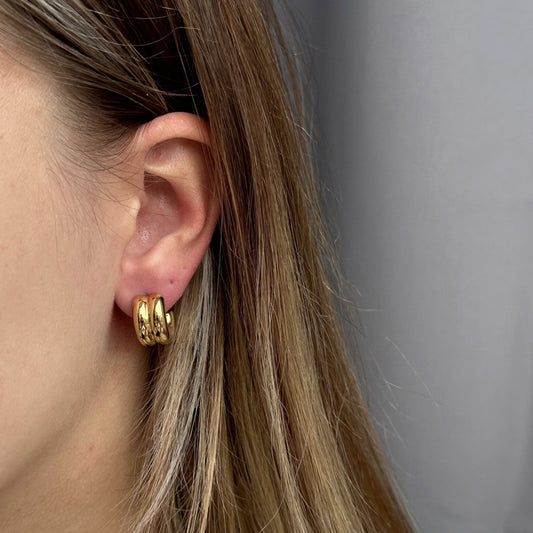 Moderne en minimalistische gouden oorring met een speels dubbellaags design