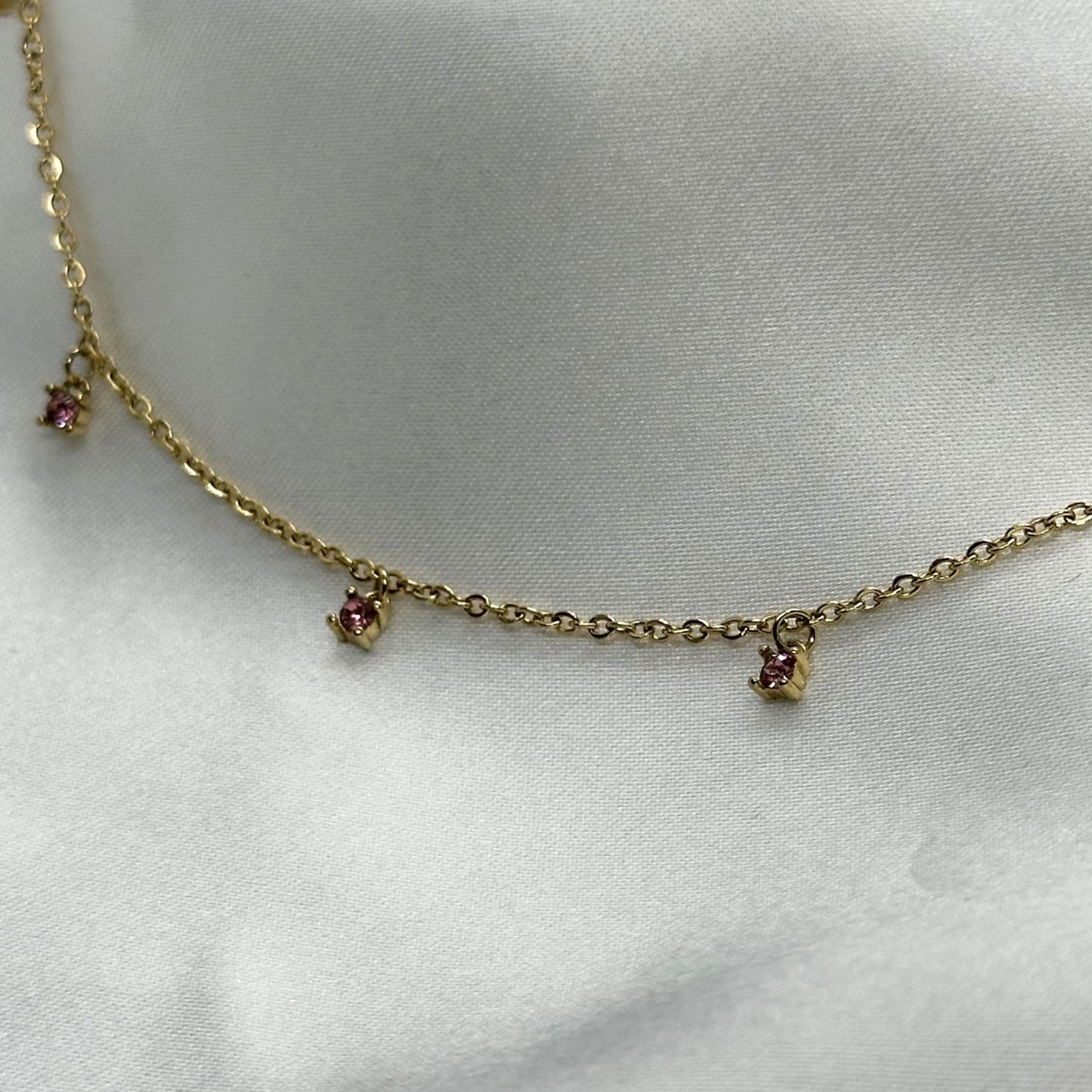 Feminine ketting met vijf kleurrijke bedels, waaronder een roze charm