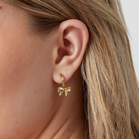 Minimalistische oorbel met een gouden strikvorm