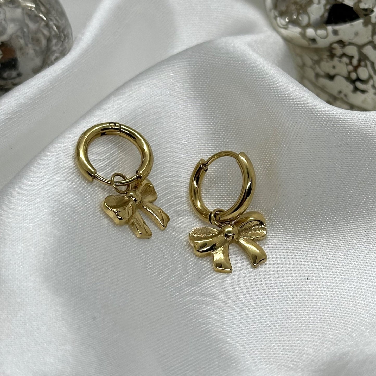 Minimalistische oorbel met een gouden strikvorm