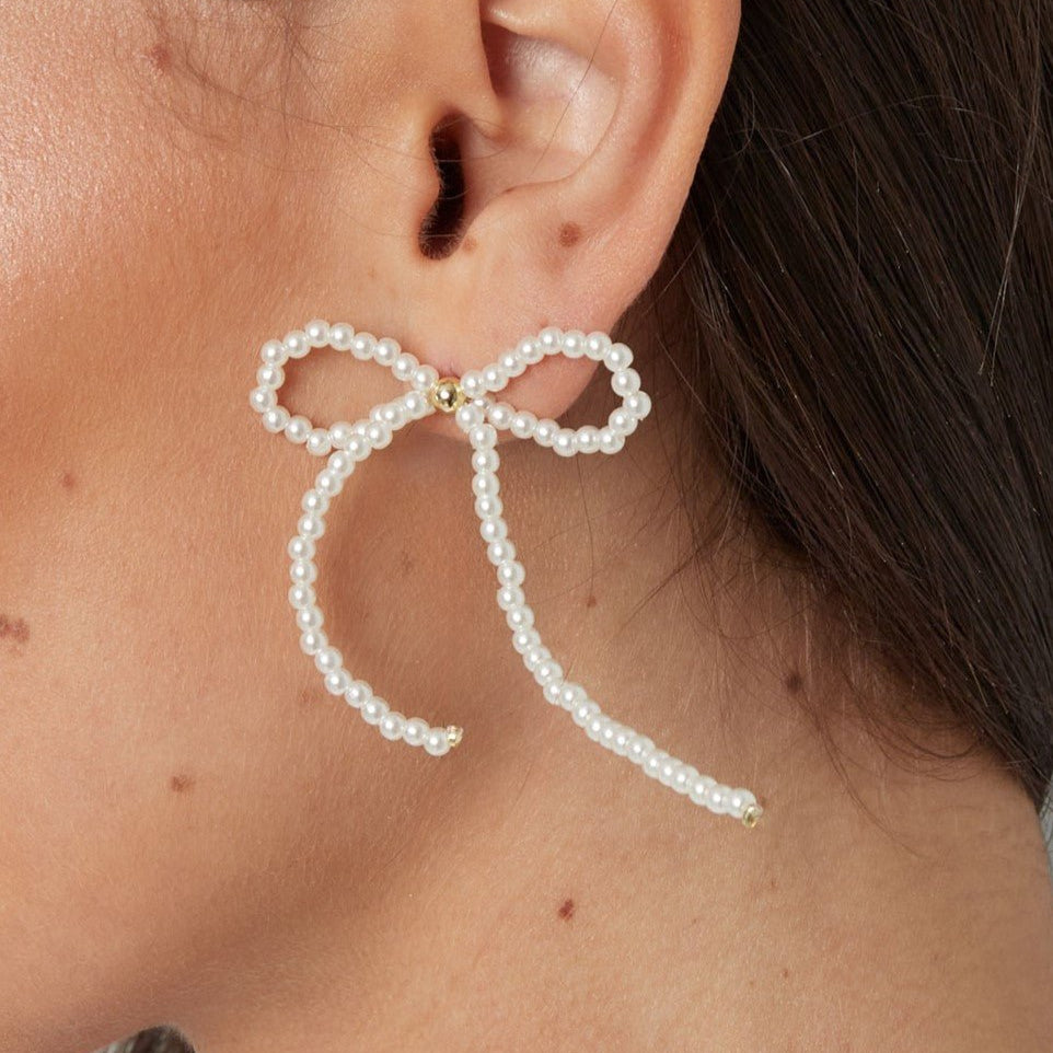 Tijdloze gouden oorbel met een stijlvolle strik en glanzende parel