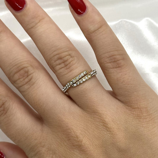 Gouden ring met een elegante wikkelvorm en sprankelende kristallen
