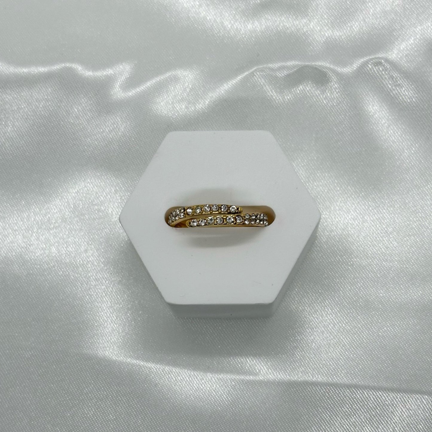 Gouden ring met een elegante wikkelvorm en sprankelende kristallen