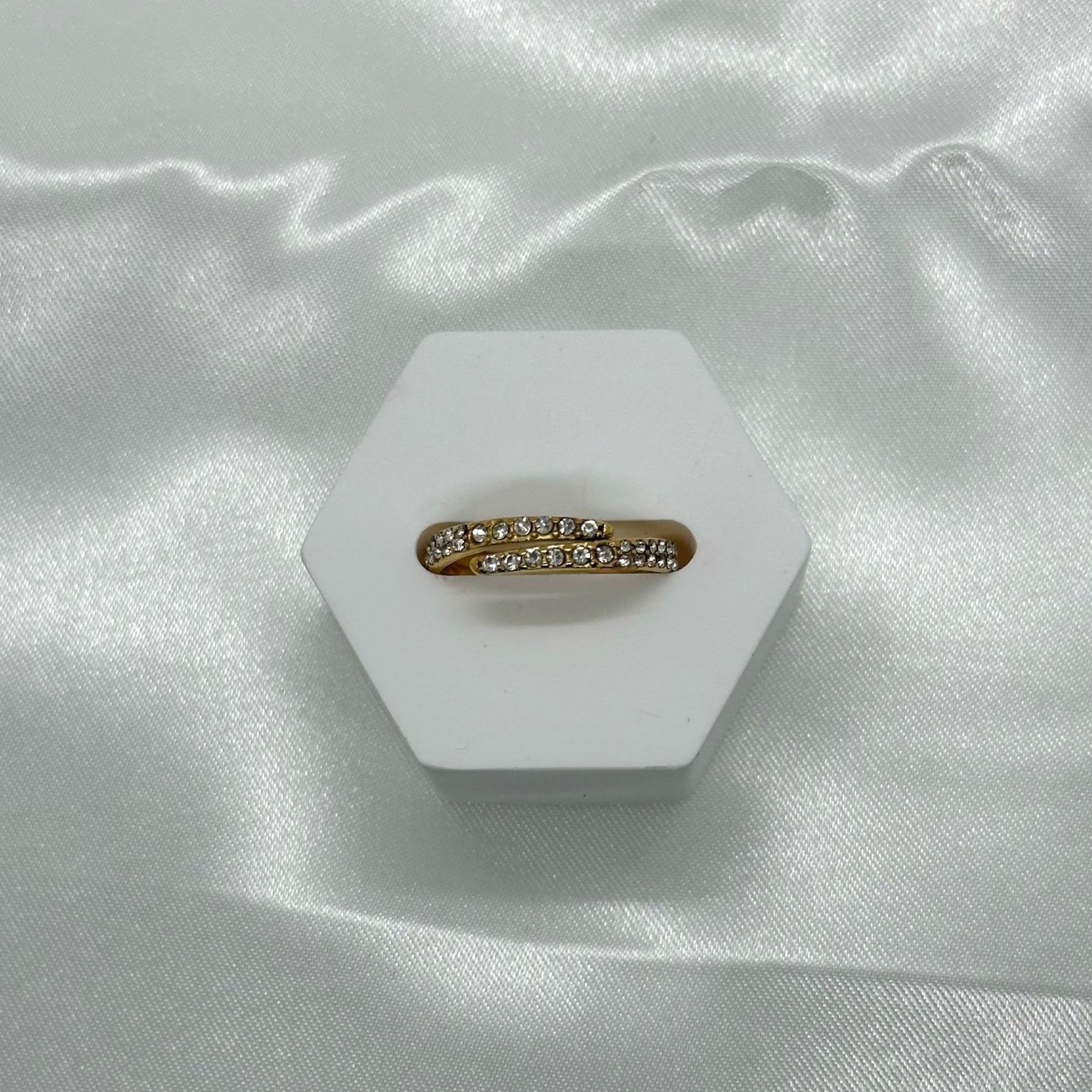 Gouden ring met een elegante wikkelvorm en sprankelende kristallen