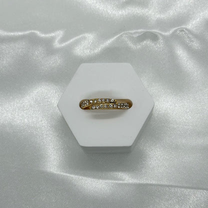 Gouden ring met een elegante wikkelvorm en sprankelende kristallen